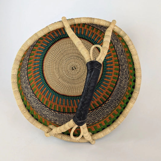 Woven basket with a handle on a light gray background