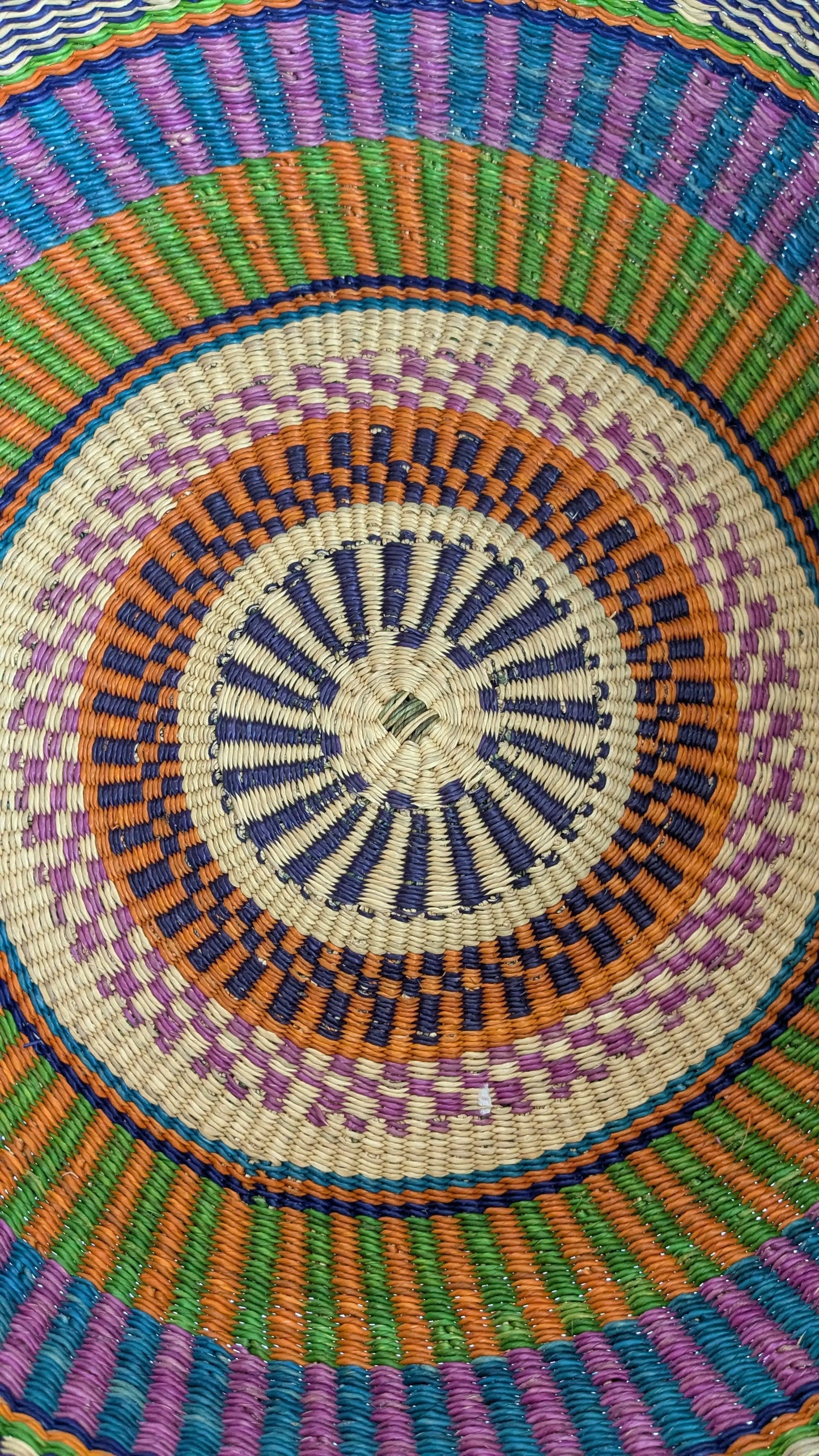 Colorful woven pattern with concentric circles in various colors.