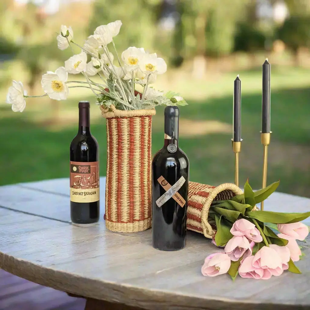 Wine carrier on an outdoor table with a wine bottle and flowers