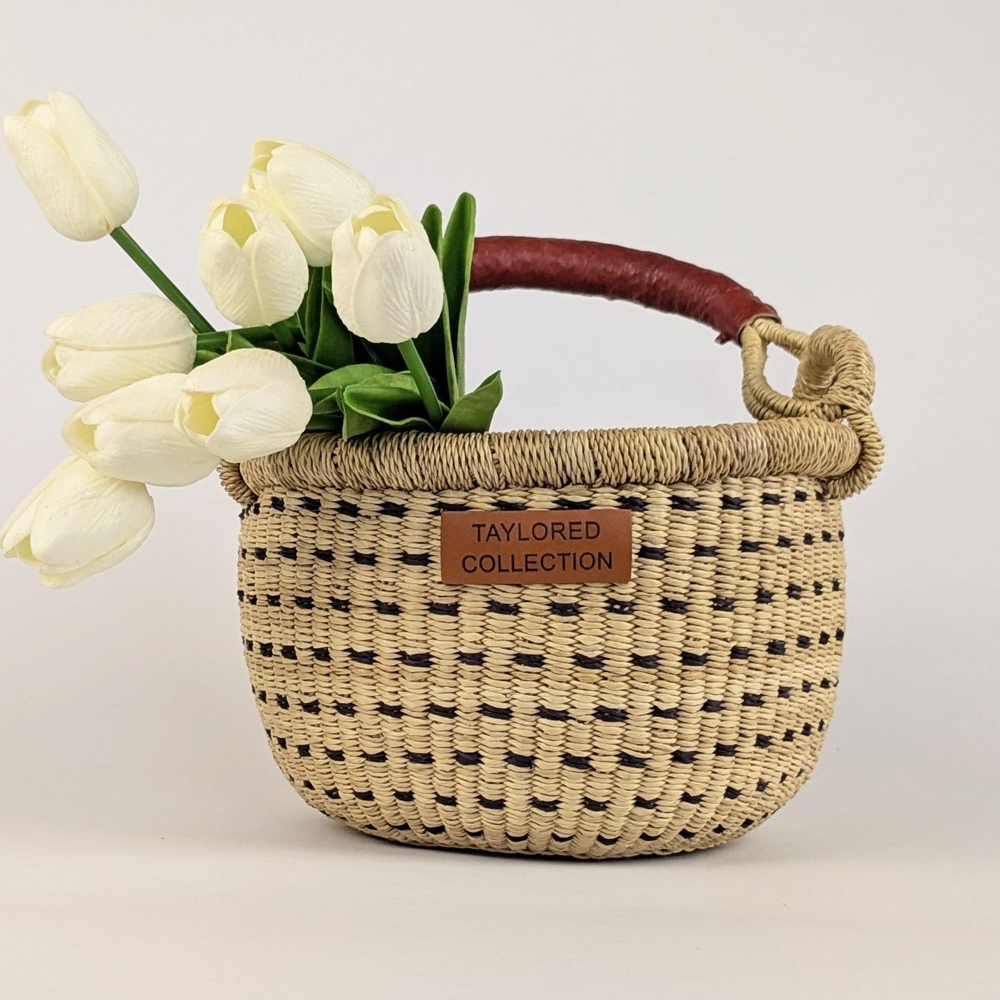 Small round gathering basket with a leather wrapped handle