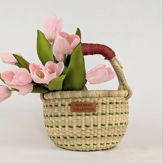 Woven basket with pink tulips and a visible brand label on a light background