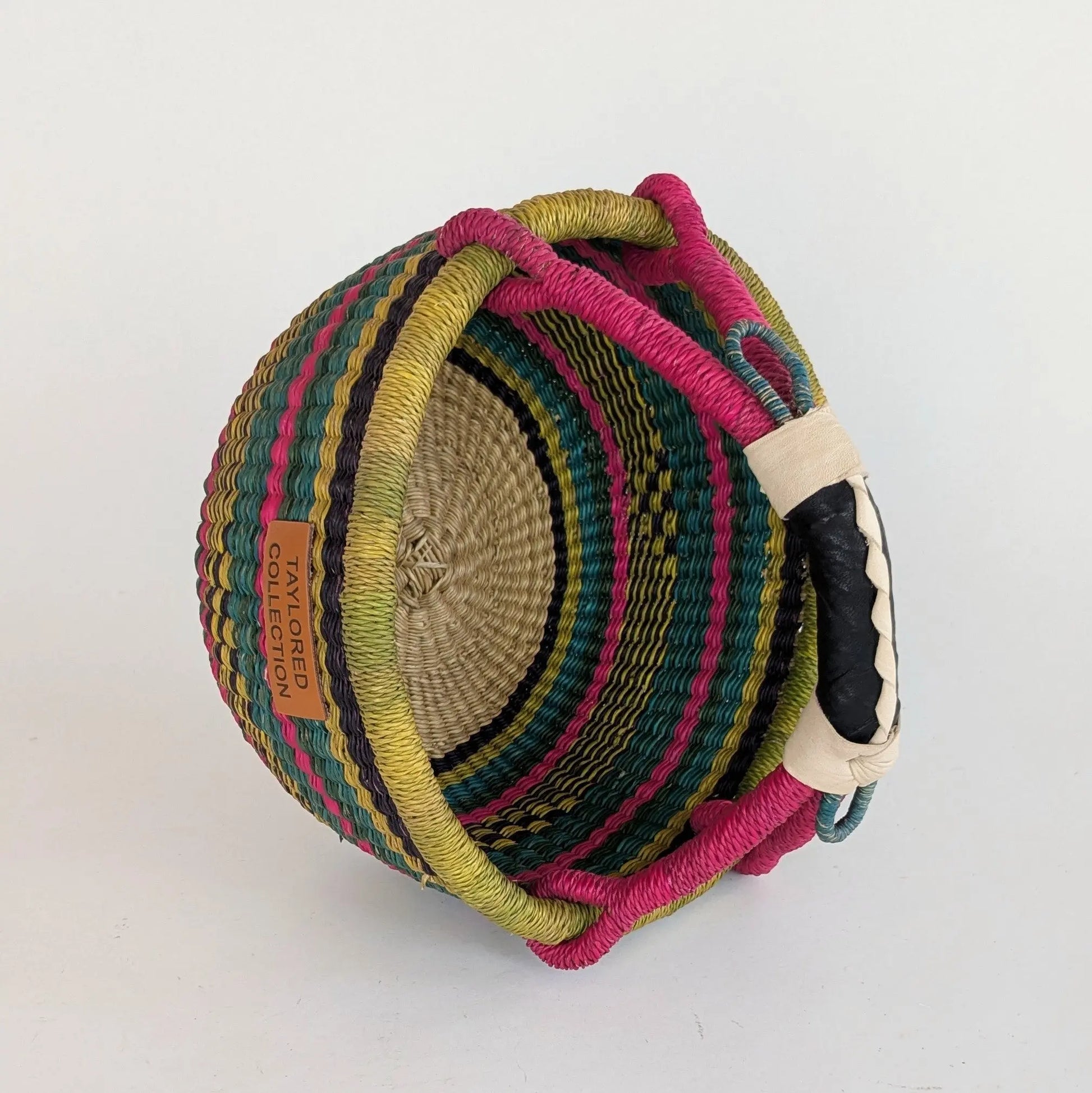 Colorful woven basket with a handle on a white background