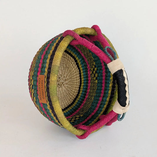 Colorful woven basket with a handle on a white background
