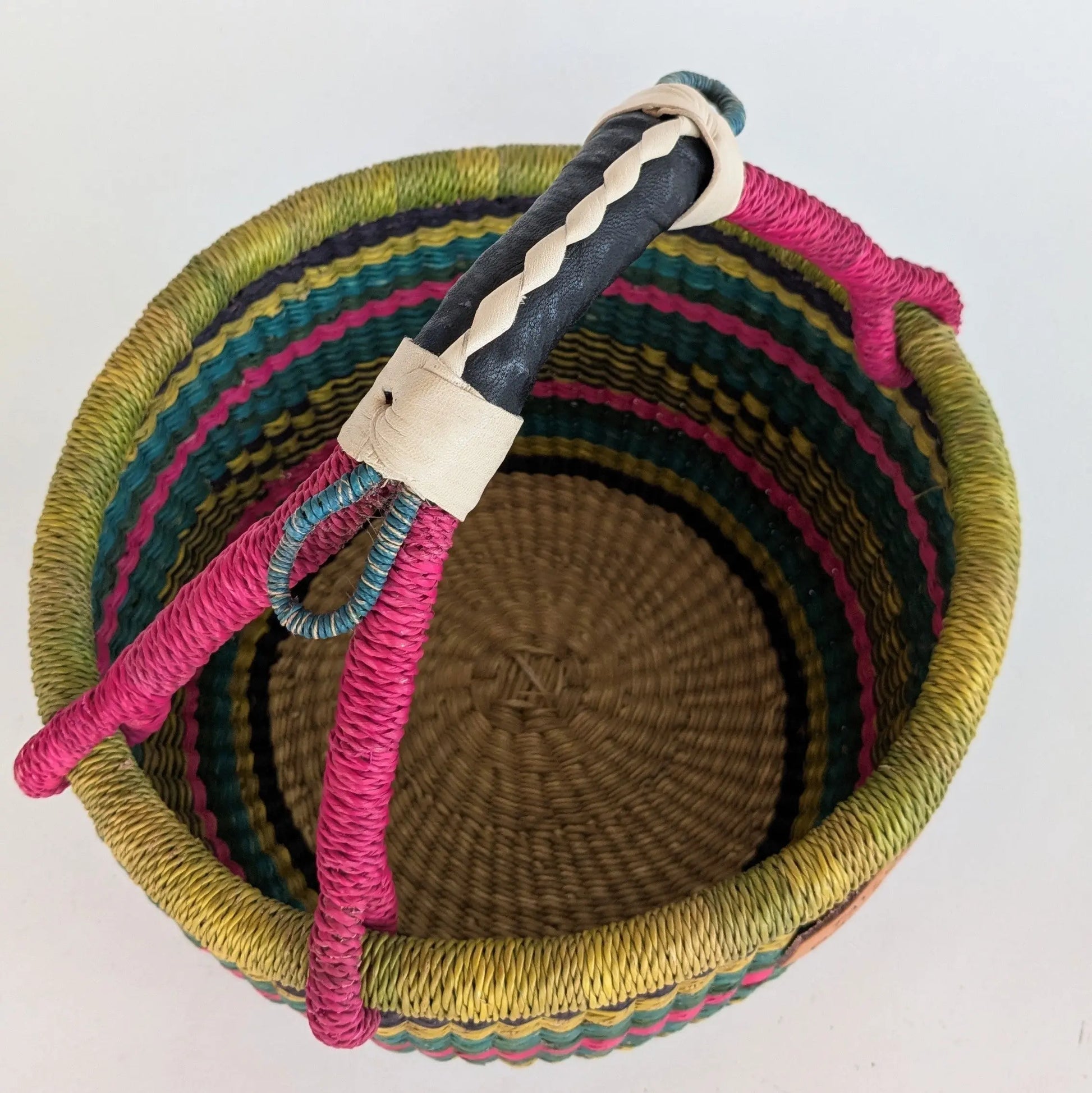 Woven basket with colorful handle on a white background