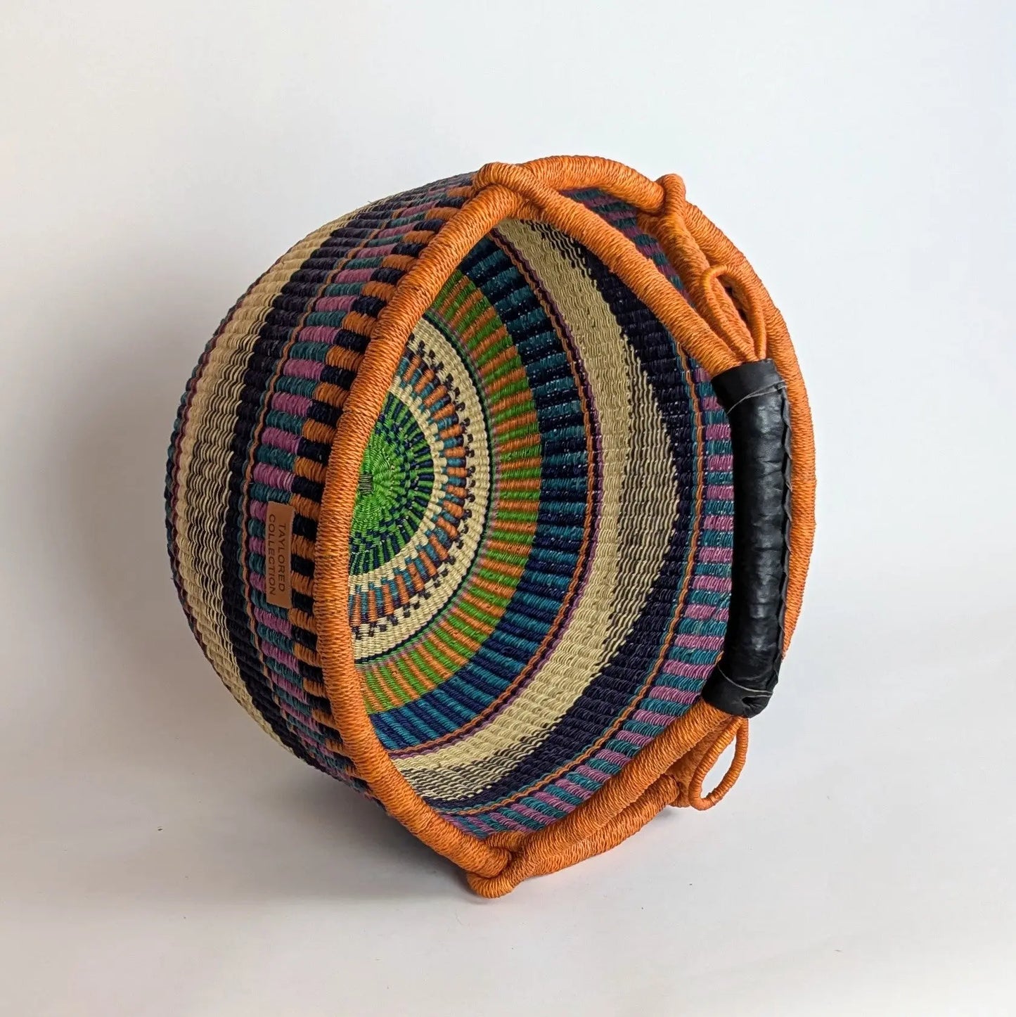Woven basket with colorful patterns on a white background