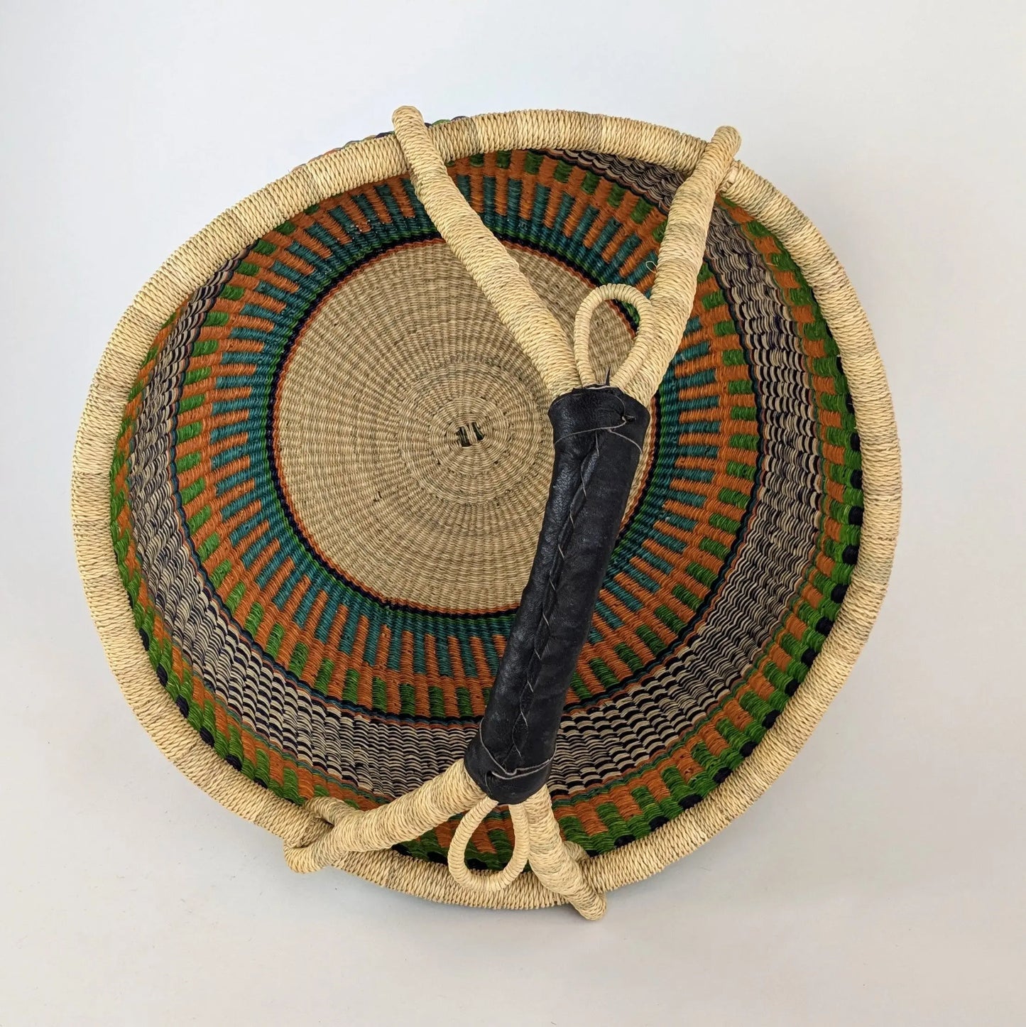 Woven basket with a handle on a light gray background