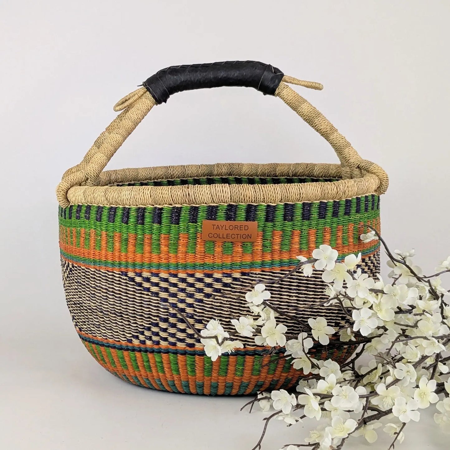 Woven basket with a handle on a white background with flowers