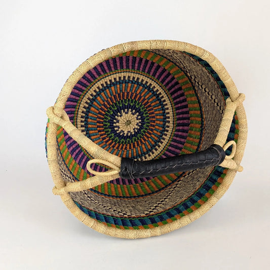 Woven basket with colorful pattern and handle on a white background