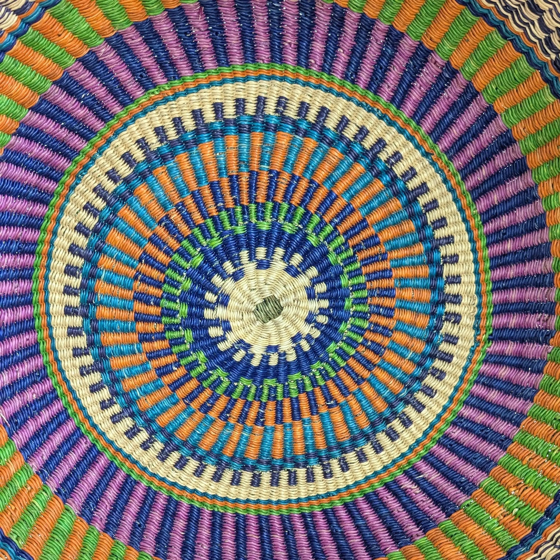 Close-up of a colorful woven circular pattern with concentric circles.