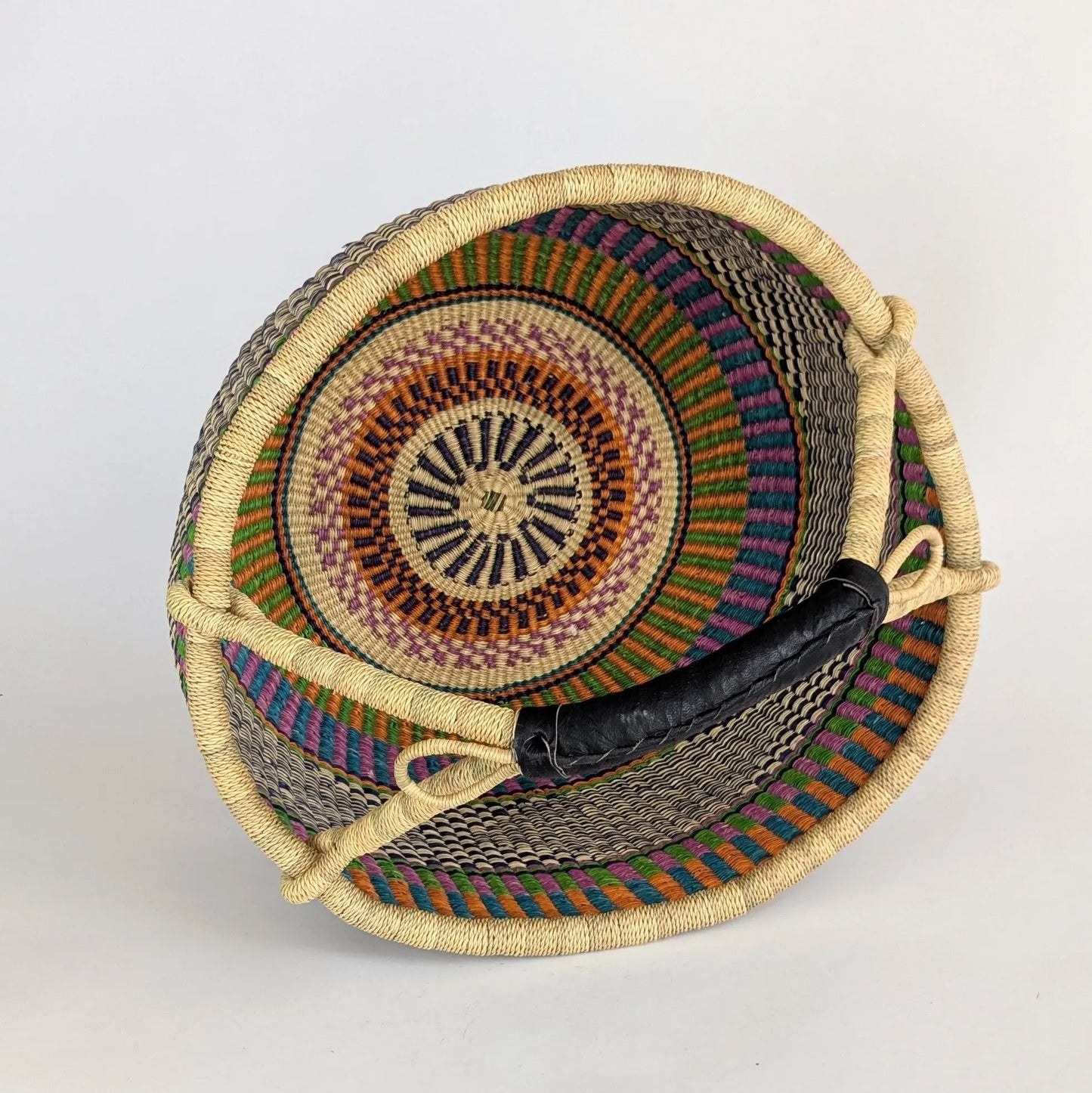 Woven basket with colorful patterns on a light gray background