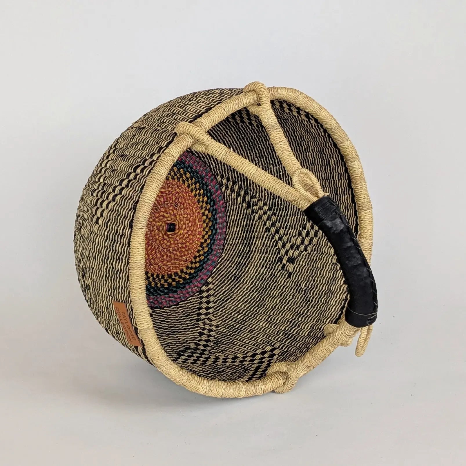 Woven basket with a handle on a light gray background