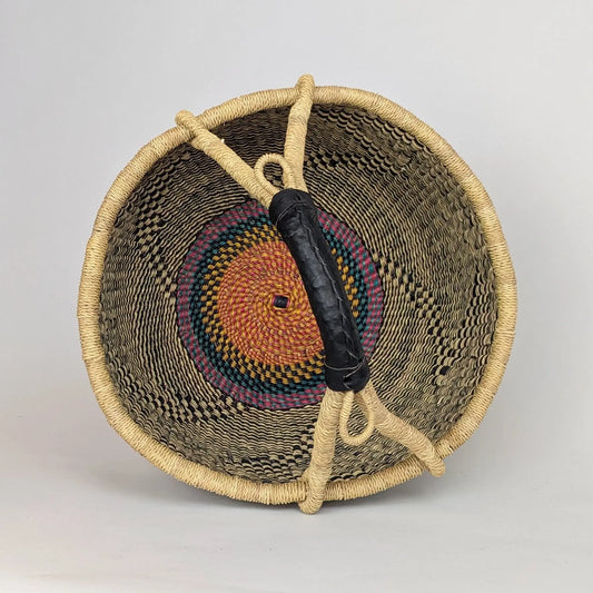 Woven basket with a colorful handle on a light gray background