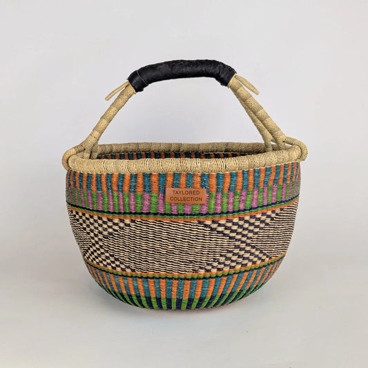 Woven basket with colorful patterns and a black handle on a light gray background